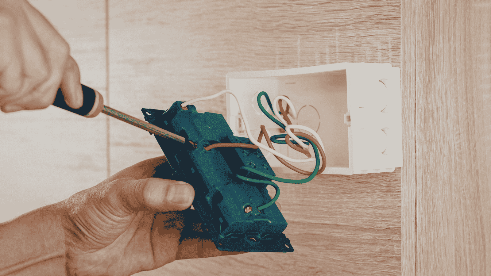 Electrician installing new electrical outlet and switch wiring in residential wall